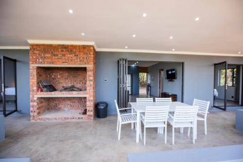 a dining room with a table and chairs and a fireplace at Sink Huis at Benlize in Pelindaba