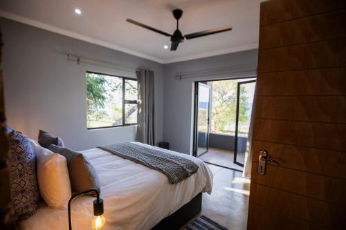 a bedroom with a bed and a ceiling fan at Sink Huis at Benlize in Pelindaba