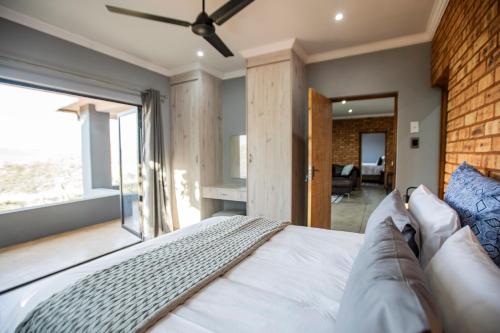 a bedroom with a bed and a large window at Sink Huis at Benlize in Pelindaba