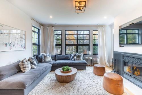 a living room with a couch and a fireplace at Unwind in Style Les Eaux 215-6 in Mont-Tremblant