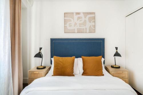 a bedroom with a bed with orange pillows and two lamps at 809-4A Columbus Circle New BLDG 1BR W D in New York