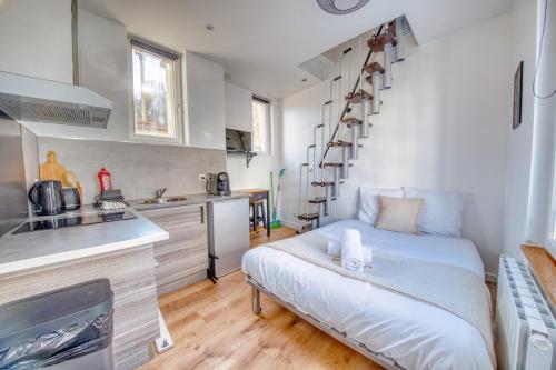 ein kleines Zimmer mit einem Bett und einer Küche in der Unterkunft Horizon Houzeau in Reims