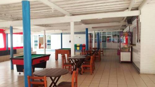 a room with tables and ping pong tables at Colônia de Férias Federação dos Papeleiros in Praia Grande