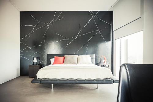 ein Schlafzimmer mit einem Bett mit einer schwarzen Wand in der Unterkunft Casa Format in Beinasco