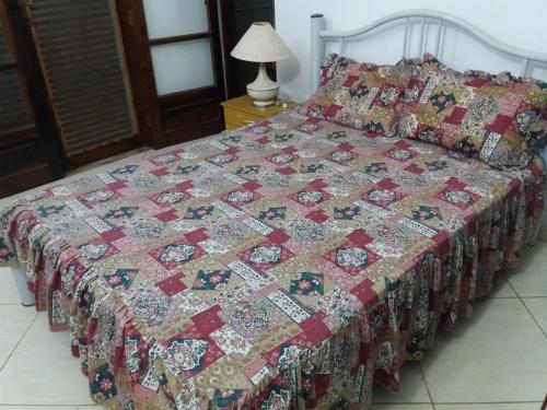 een bed met een quilt erop in een slaapkamer bij Chacara Casa de Campo in Tietê