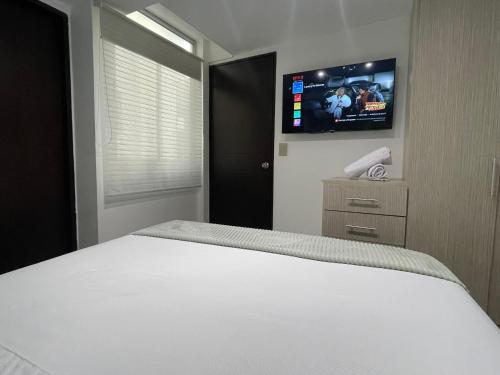 a bedroom with a bed and a flat screen tv at Luxury liv Gran limonar in Cali