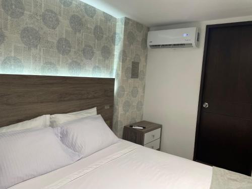 a bedroom with a white bed and a wall at Luxury liv Gran limonar in Cali