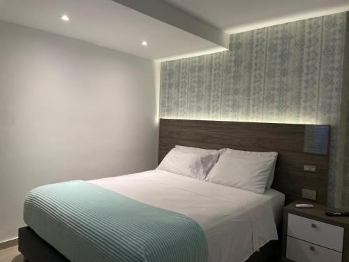 a bedroom with a large bed with a wooden headboard at Luxury liv Gran limonar in Cali