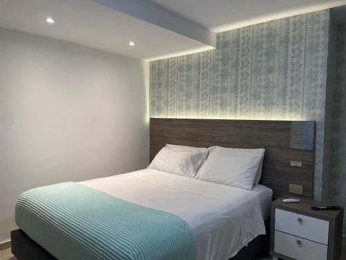 a bedroom with a large bed with a wooden headboard at Luxury liv Gran limonar in Cali