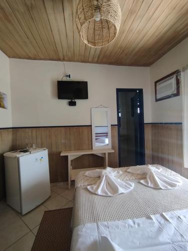 a bedroom with a bed and a tv on the wall at Pouso Trindade in Trindade