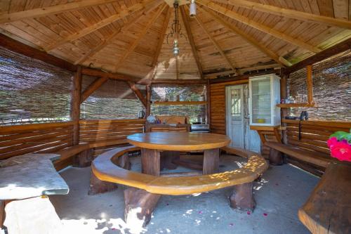 a room with a table and benches in a cabin at Siedlisko Bogdanka in Leszczewek