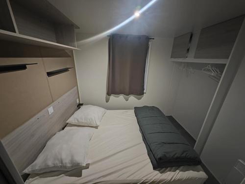 une petite chambre avec un lit et une fenêtre dans l'établissement Mobile home camping les sables d'or, au Grau-dʼAgde