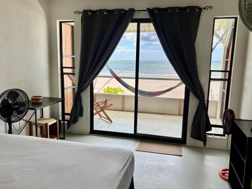a bedroom with a bed and a view of the beach at Stella Mar Oceanfront Hotel in Popoyo