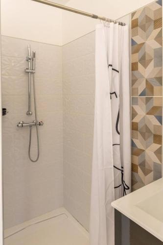 une salle de bain avec une douche avec un rideau de douche dans l'établissement Casa Fernandes avec piscine couverte, à Bourg-en-Bresse