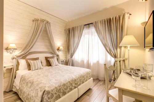 ローマにあるCasa Tua Vaticano Guest Houseのベッドルーム1室(ベッド1台、デスク、窓付)