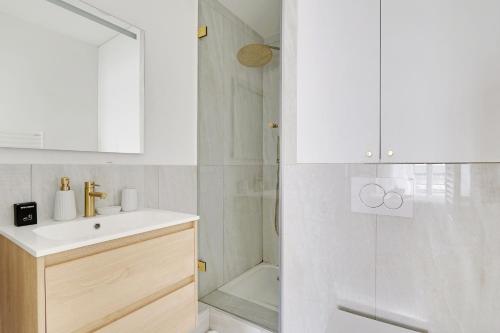 une salle de bain avec un lavabo et une douche dans l'établissement Lovely Studio in Paris, à Paris