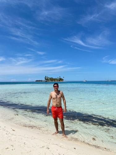 a man standing on a beach in the water at Isla del barco hundido habitacion privada en San blas in Niatupo