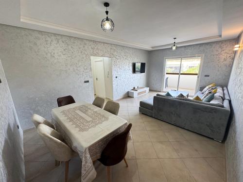 a living room with a couch and a table at Luxe Appartement - vue sur montagne Plage, Piscine & Jeux pour Enfants in Imi Ouaddar