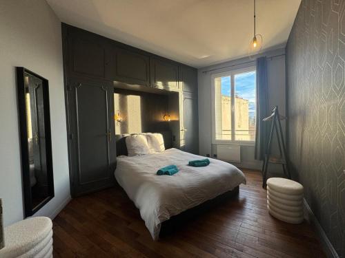 una camera da letto con un letto e una grande finestra di Le petit Lyautey - Retro-chic atmosphere a Vichy