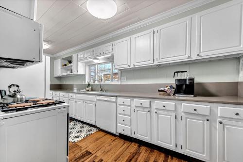 a kitchen with white cabinets and a stove top oven at University Place, family stay, practically on JBU campus in Siloam Springs