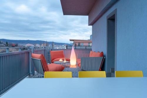 un balcón con sillas y una mesa con una vela en The sunset terrace, en Koliba