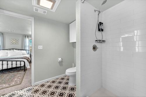 a bathroom with a shower with a toilet and a bed at University Place, family stay, practically on JBU campus in Siloam Springs