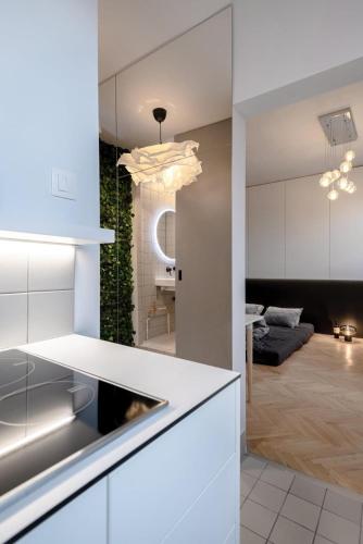 a kitchen with white cabinets and a living room at The sunset terrace in Koliba