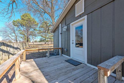 a wooden porch with a door and a bench at University Place, family stay, practically on JBU campus in Siloam Springs