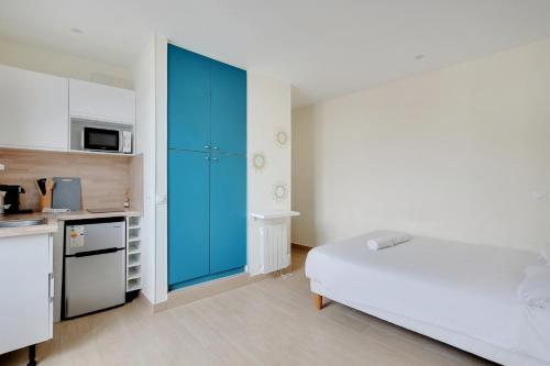 - une chambre avec un lit et une armoire bleue dans l'établissement Charmant Studio Aubervilliers, à Aubervilliers