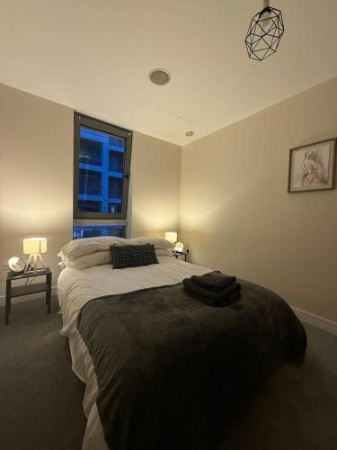 Un dormitorio con una cama grande y una ventana. en 2 bedroom Titanic Apartment - 1 night stays!, en Belfast