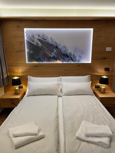 a bedroom with a white bed with two towels on it at Chalet Lilla Livigno in Livigno