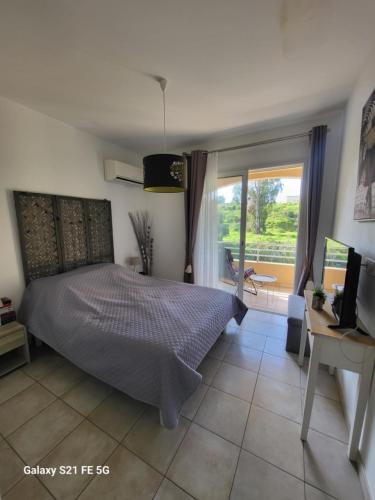 une chambre avec un lit, un bureau et une fenêtre dans l'établissement T3 Vue mer bord de mer, à Albitreccia