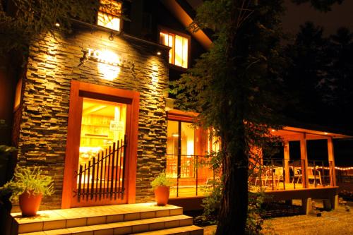 a brick building with a porch at night at Pension Tomato in Hakuba