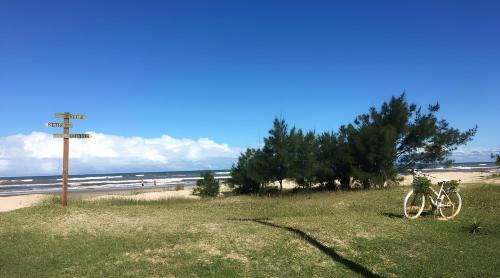 two bikes parked on the grass next to the beach at Casa de praia na Paraíso in Torres