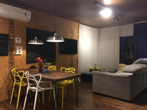 a living room with a table and chairs and a couch at Bluemenhaus, casa inteira com jardim a 1km da Vila Germânica in Blumenau
