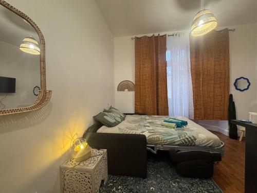 une chambre avec un lit et un miroir au mur dans l'établissement Le Marrakech - Studio, à Vichy