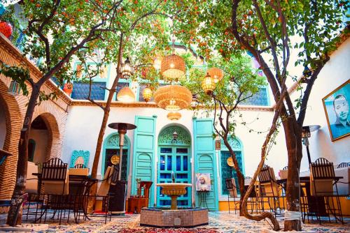 a building with a table and chairs and trees at Riad Al Nour in Marrakech
