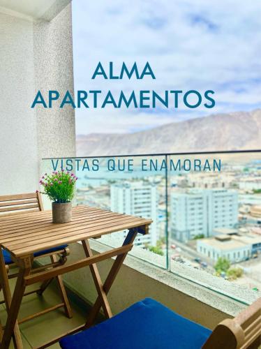 a table and chairs on a balcony with a view of a city at Apartamento Alma Capital in Iquique