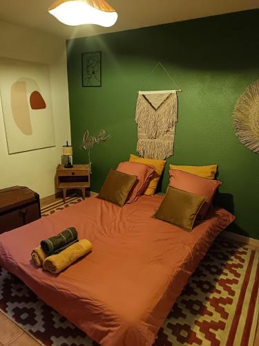 un grand lit dans une chambre avec un mur végétal dans l'établissement LePimpant, à Avignon