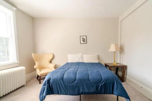 a bedroom with a blue bed and a chair at The Carew House Sleeps 10 Fenced 4BR Full Kitchen Steps2 YCP in York