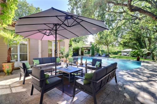 - une terrasse avec une table et un parasol à côté de la piscine dans l'établissement Charming Provence Retreat with Heated Pool and Jacuzzi, à Saint-Cannat