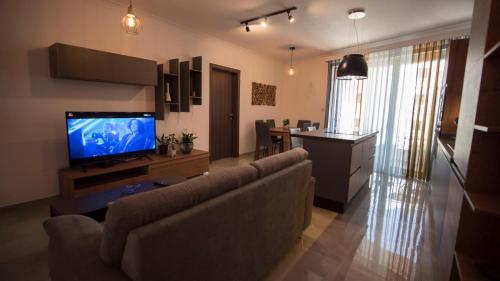 a living room with a couch and a flat screen tv at Msiebah Court San Gwann Modern Apt near Sliema and St Julians in San Ġwann
