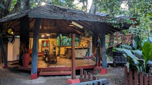 a wooden pavilion with a hammock in a garden at Tree House Beachfront Lodge in Puerto Viejo