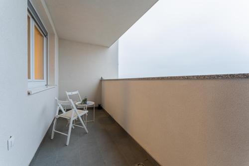 Una habitación con dos sillas y una mesa y una ventana. en Flex SelfCheckIns 138 - Zagreb - Bedroom - Parking - Loggia, en Zagreb