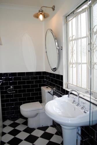 a bathroom with a sink and a toilet and a mirror at Edward Lodge New Fam in Brisbane