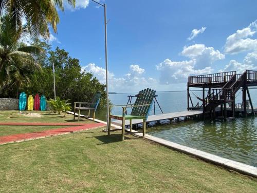 two benches sitting on a dock next to the water at Coras Place Bacalar Lagoon front in Bacalar