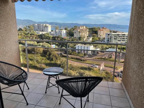 un balcon avec des chaises et une vue sur la ville dans l'établissement Appartement vue sur le golfe d ajaccio, à Ajaccio