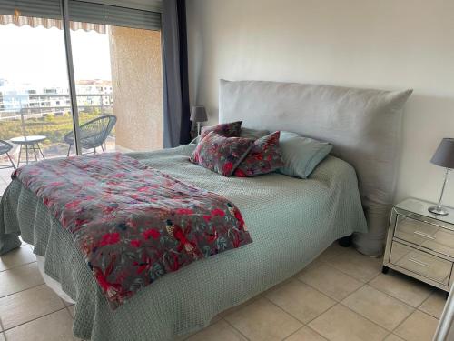 ein Schlafzimmer mit einem Bett mit einer roten Decke und einem Fenster in der Unterkunft Appartement vue sur le golfe d ajaccio in Ajaccio