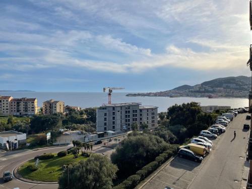 einen Blick auf die Stadt mit Autos auf einem Parkplatz in der Unterkunft Appartement vue sur le golfe d ajaccio in Ajaccio