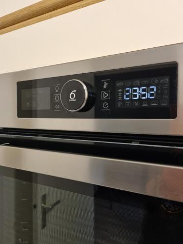 une fermeture d'un four micro-ondes avec ses commandes dans l'établissement Hermès Apartment - Versailles Château, à Versailles